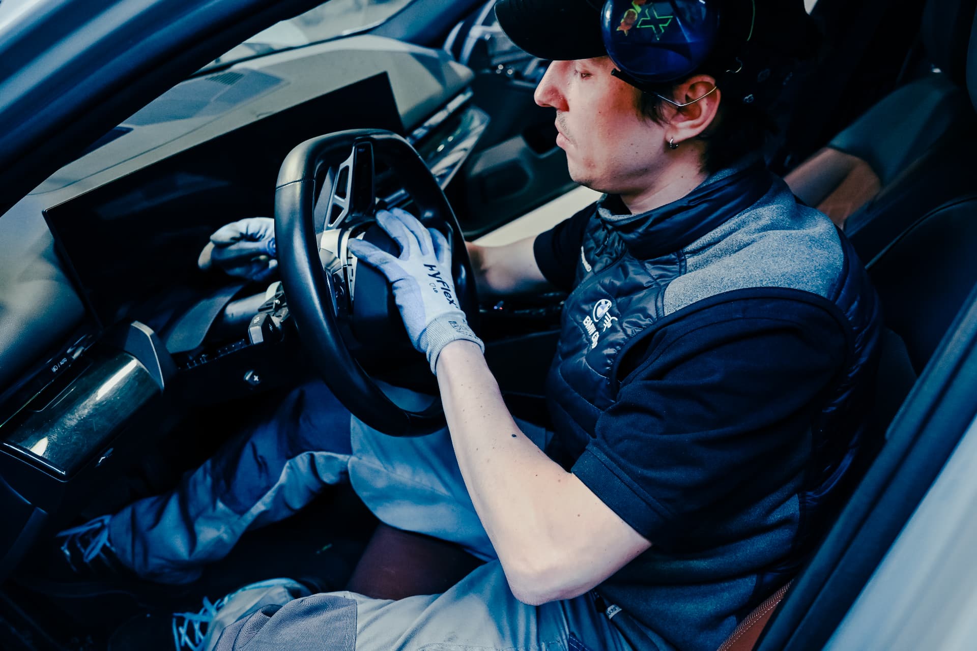 BMW technician working at the steering wheel inside a vehicle at the Recycling & Demontage Zentrum