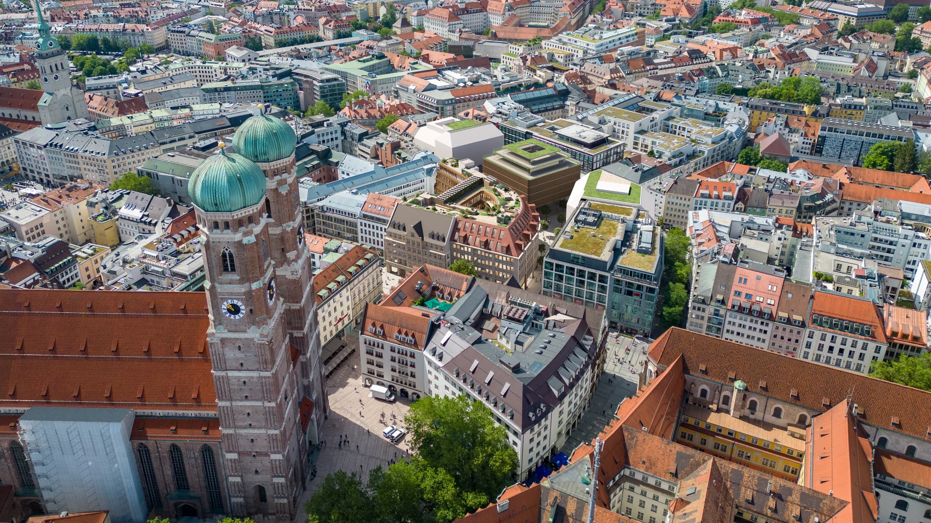 Aerial view over Munich's old town with the Frauenkirche towers, looking across the city center toward the Georg Kronawitter Platz quarter