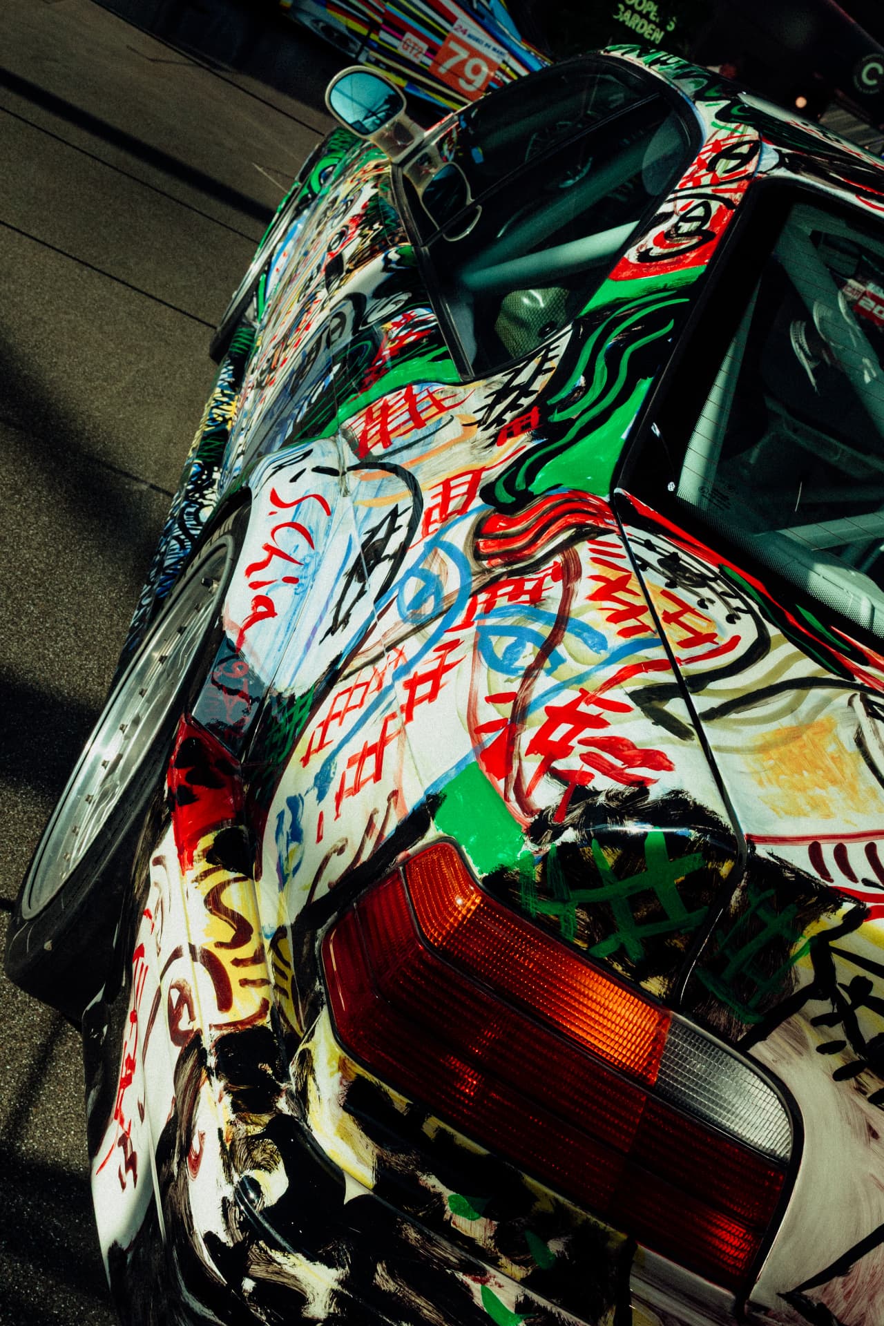 Portrait detail of expressive hand-painted artwork across a BMW Art Car body