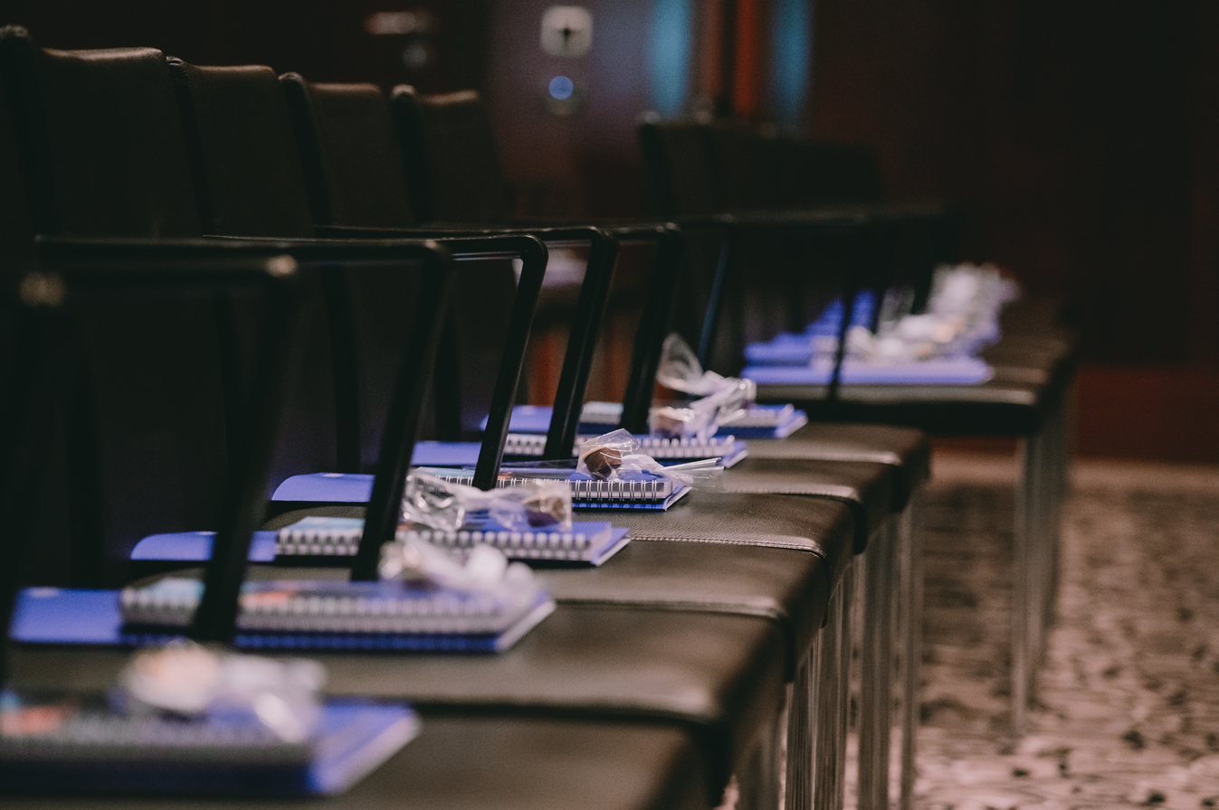 Conference chairs with notebooks and headsets prepared for NOERR Competition Day attendees