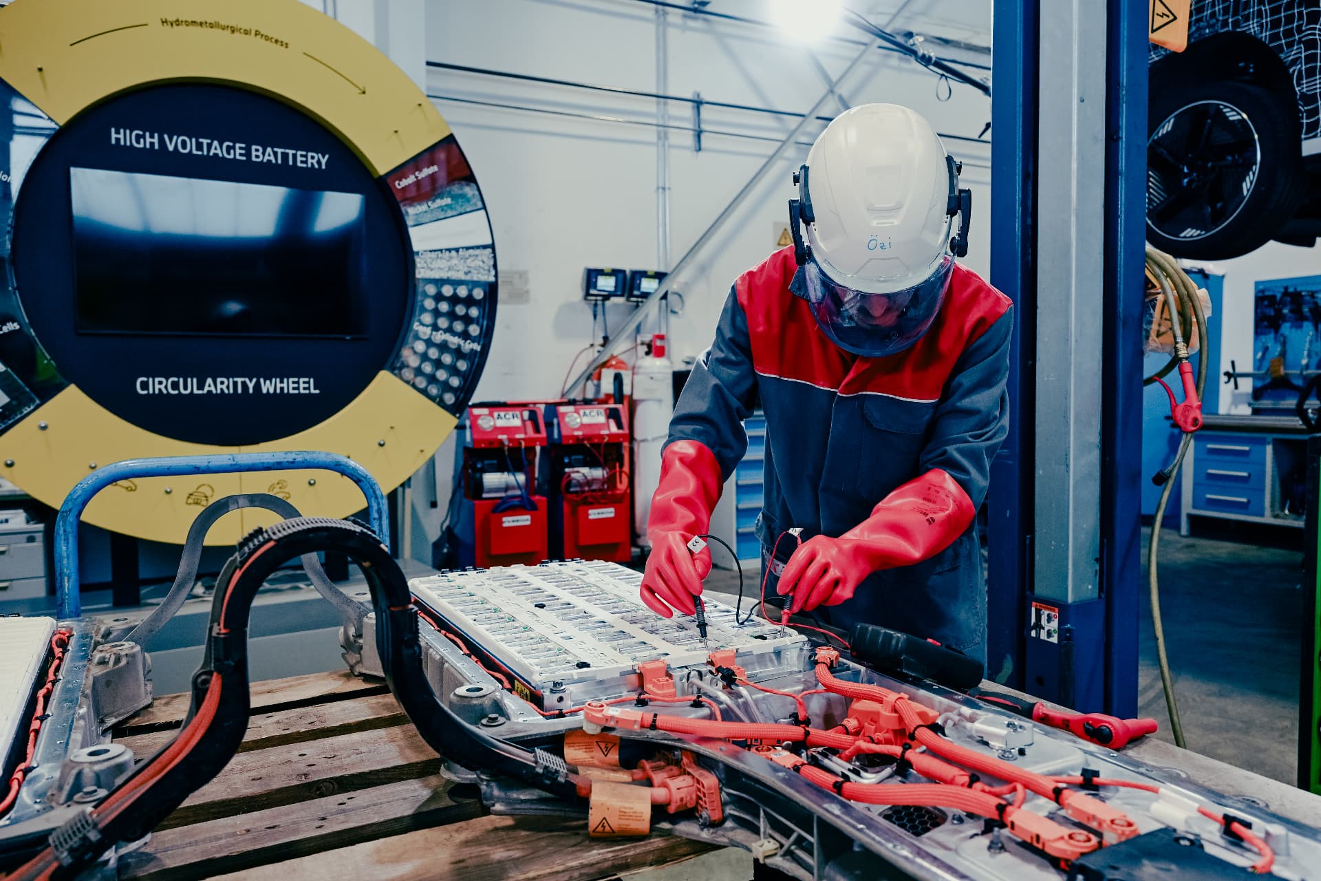 BMW technician in protective equipment testing a high voltage battery at the Recycling & Demontage Zentrum