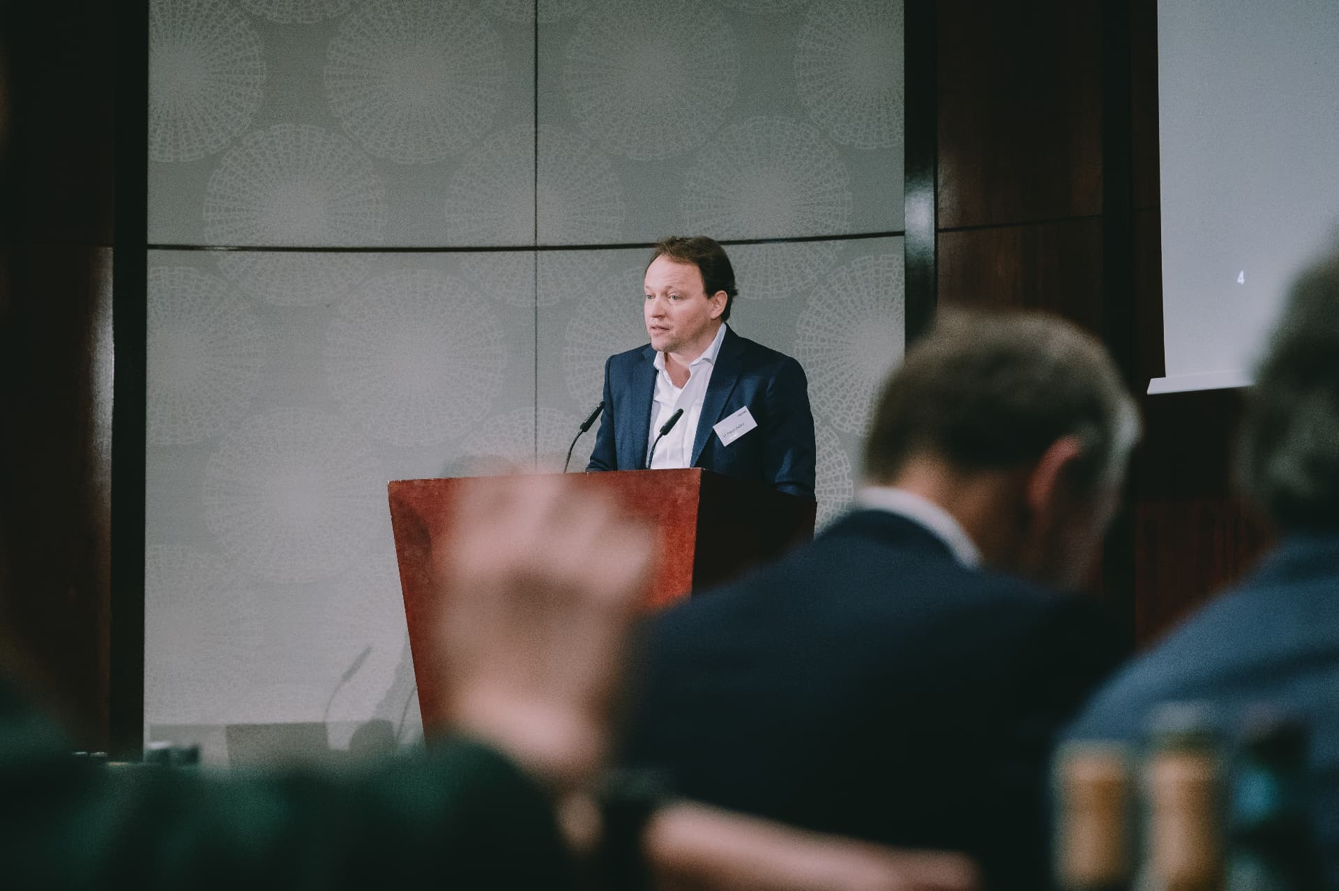 Speaker addressing the NOERR Competition Day audience from a wooden lectern
